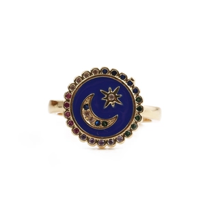 Detailed macro view of gold adjustable ring with blue enamel moon and star design