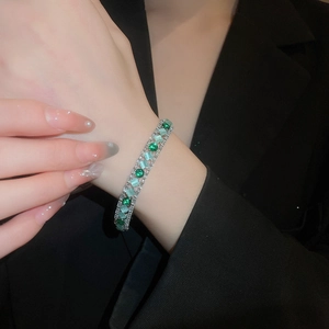 Detail of emerald and mint zircon bracelet on wrist with elegant silver metal finish