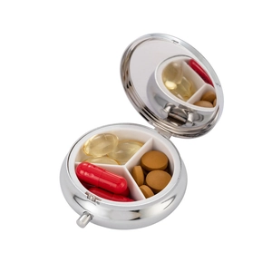 Silver metal pill box with 3 compartments and a built-in mirror shown from 45-degree angle