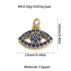 Macro view of gold-plated evil eye pendant with blue and clear cubic zirconia inlays