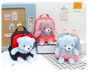 Three colorful children's plush bear backpacks with detachable dolls in a creative display