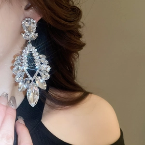 Gros plan d'un mannequin portant des boucles d'oreilles losanges en forme de goutte d'eau
