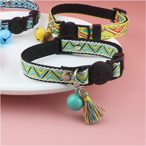 Detailed close-up of woven cat collars with tassels and bells on a white display