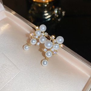 Macro view of gold plated pearl earrings with sparkling crystals in a jewelry box