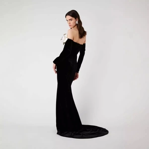 Off-shoulder black velvet mermaid evening gown with white floral trim and long sleeves
