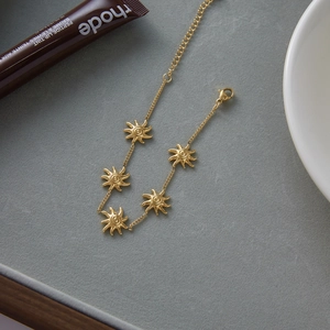 Dettaglio del bracciale con ciondoli a sole in acciaio inossidabile placcato oro 18K