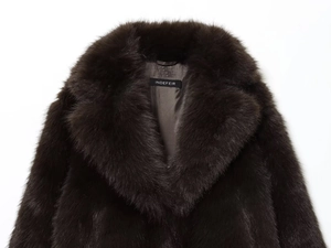 Gros plan d'un manteau en fausse fourrure marron foncé montrant la texture et le revers