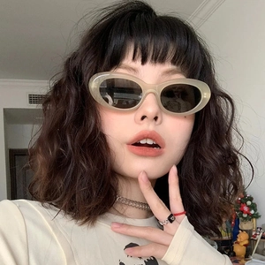 Retro oval sunglasses with beige resin frames and dark grey lenses on model