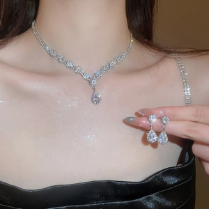 Detailed close-up of water drop zircon necklace and earrings set with silver finish