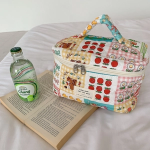 Détail de la trousse de maquillage en coton matelassé avec motif patchwork et double zip