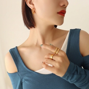 Gold plated titanium twisted C-hoop earrings and quilted texture ring set on model