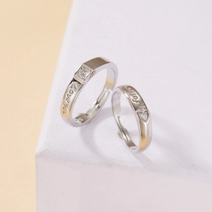 Detail of silver and gold couple rings with Love You and Forever side engraving