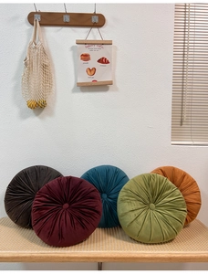 Detailed group shot of colorful round velvet pumpkin pillows in rich assorted jewel tones