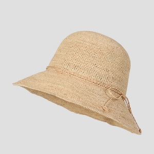 Detailed close-up of a raffia straw sun hat with a delicate bow ribbon decoration