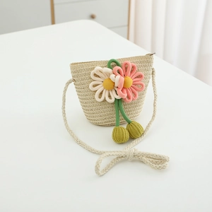 Detail view of straw crossbody bag with floral accents and thin braided shoulder strap
