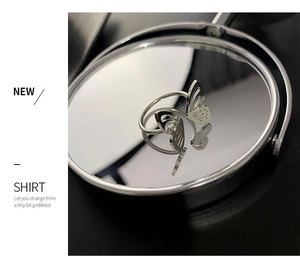 Detailed close-up of a silver butterfly open ring with hollow wings on a mirror