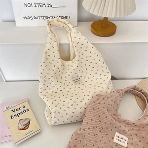 Close-up of floral corduroy tote bags with vintage pattern and brand label detail