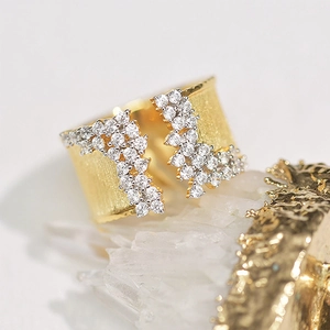 Detailed macro view of gold-plated ring with brushed texture and zircon clusters on stone