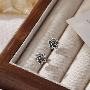 Vintage silver rose flower stud earrings in titanium steel with detailed petal texture