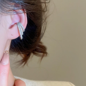 Close-up of a triple-layered silver ear cuff with zircon stones on a model ear