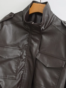 Detailed view of dark brown leather jacket with stand collar and flap chest pockets