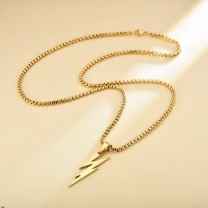 Men's gold lightning bolt pendant on box chain necklace over elegant sunlit background