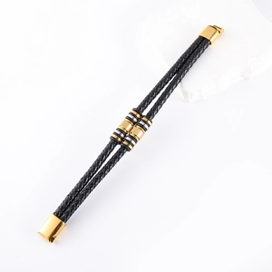 Detailed macro view of double-layer braided leather bracelet with gold and silver metal beads