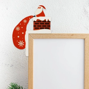 Wooden Santa Claus sitting on chimney door frame corner decor with red gift bag