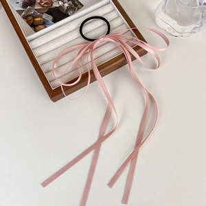 Close-up of pink long ribbon bow hair tie with smooth satin finish and sleek design