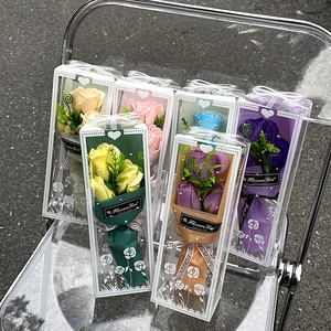 Detailed view of assorted soap flower bouquets in transparent gift boxes with white bows