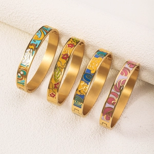 Detailed close-up of four gold 18K vacuum plated enamel bangles with artistic patterns
