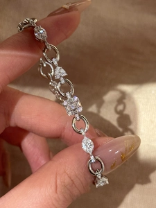 Macro shot of silver zircon chain bracelet featuring geometric multi-cut stones