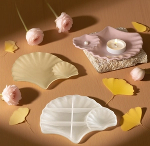 Detailed scene of shell-shaped resin trays and silicone molds on a warm background
