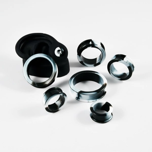 Detail view of black and white marble silicone ear gauges set with ear model display