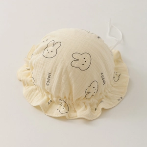 Detail of ruffled beige baby bonnet featuring rabbit prints and soft double gauze cotton