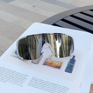 Close-up of white sports sunglasses with silver mirrored lenses on a fashion magazine