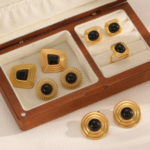 Golden geometric jewelry set with black zircon earrings and ring in a wooden box