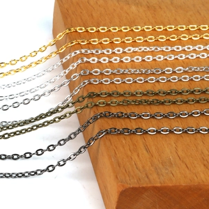 DIY Schmuckketten in Gold, Silber, Bronze und Schwarz auf einer Holzoberfläche