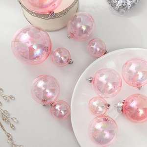 Boules de Noël roses iridescentes avec attaches argentées sur fond blanc