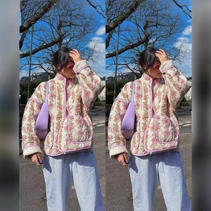 Vintage floral quilted jacket with pink piping and large pockets in a street style shot