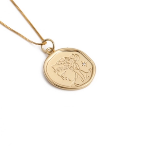 Close-up of vintage coin pendant necklace with goddess relief in gold plating