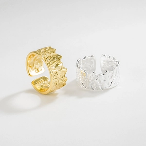 Anelli aperti S925 con trama lava in finitura oro e argento su sfondo grigio