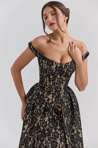 Détail de dentelle florale noire sur doublure beige d'une robe de soirée à épaules nues
