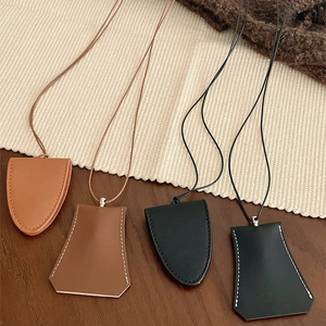 Detail view of assorted PU leather key pouches in brown and black on a wooden background