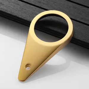 Macro shot of matte gold drop-shaped metal opener component with sandblasted finish