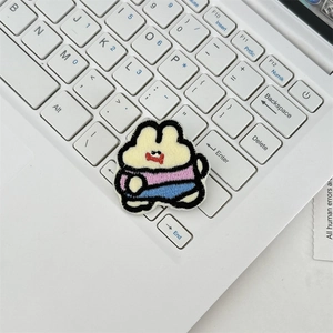 Close-up of a cartoon rabbit embroidery patch with detailed texture on a white keyboard