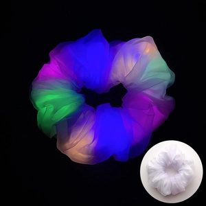 Gros plan de chouchous LED en résille colorée brillant dans l'obscurité totale