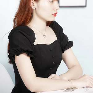 Detail shot of a silver hollow heart necklace and earrings set worn by a model