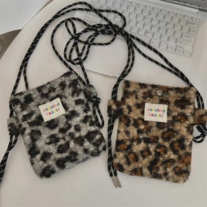 Vue détaillée de sacs bandoulière en peluche léopard gris et marron avec cordons de serrage