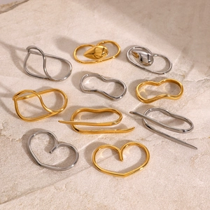 Minimalist liquid metal stainless steel rings in gold and silver on stone